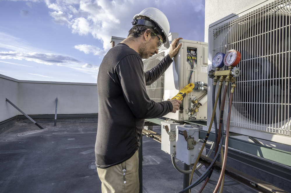 Professional HVAC technician taking an amperage reading on a mini-split ductless air conditioning system.